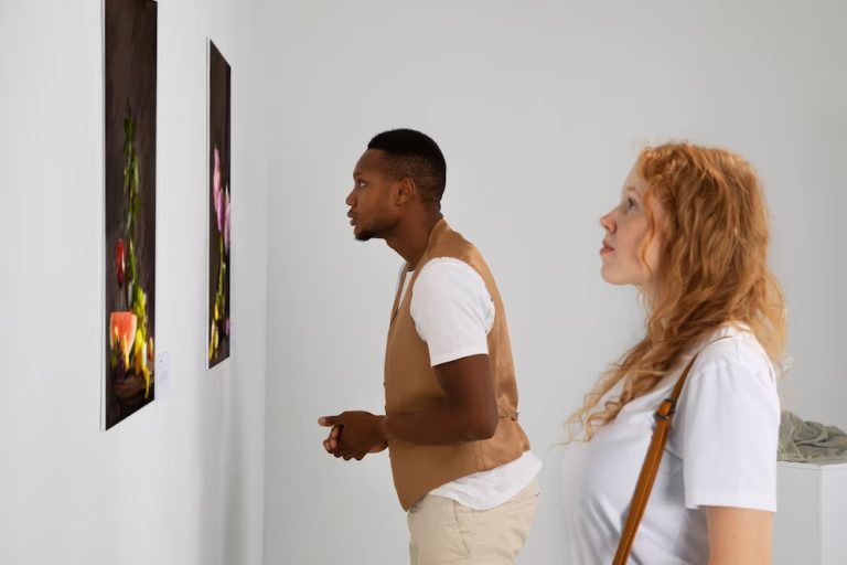 Two people closely examining a painting on a gallery wall.